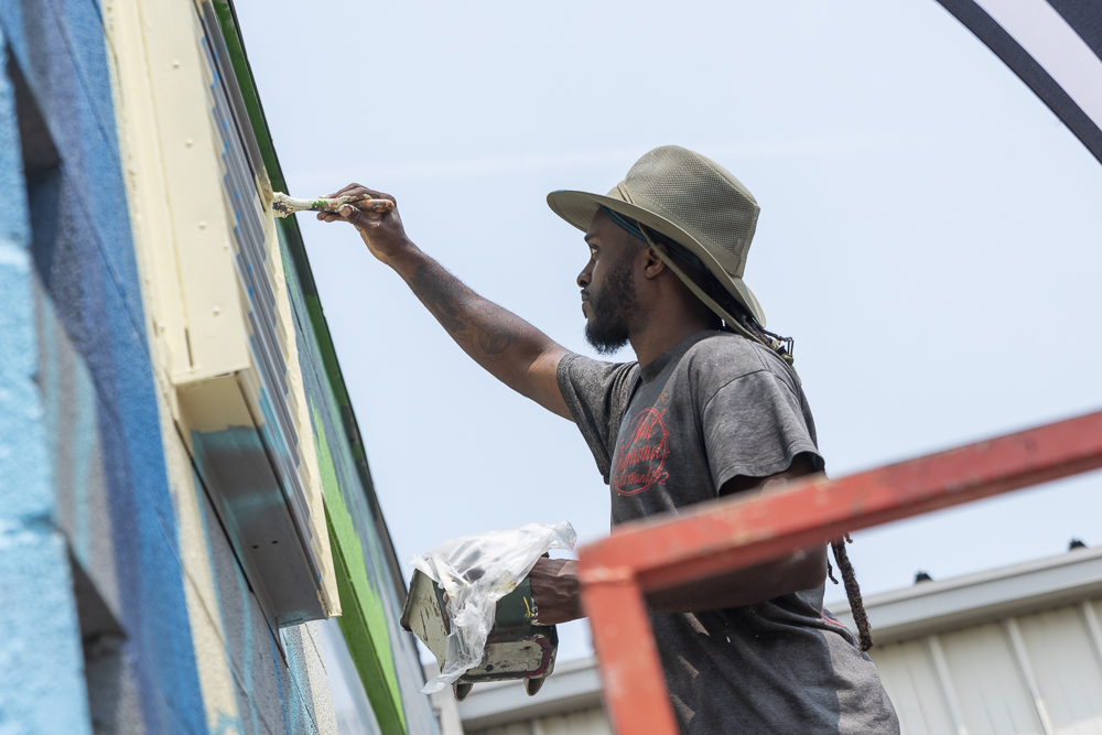 Isaiah Williams painting his Emerald Necklace mural