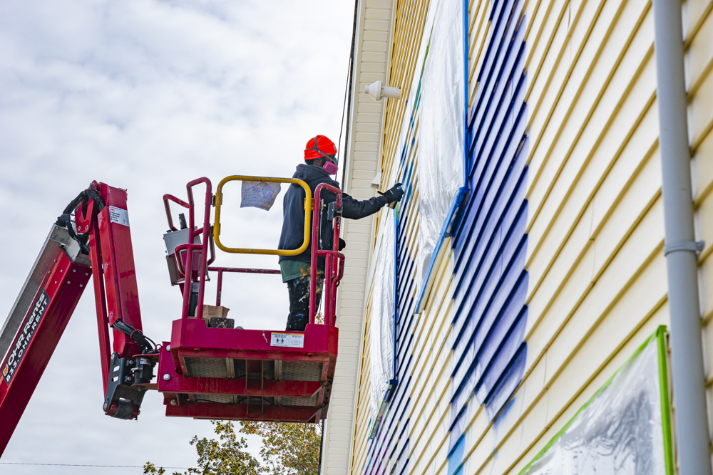 Isaiah Williams working on the Facing History Mural