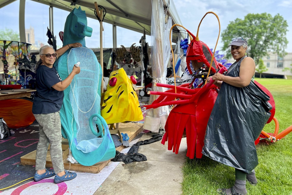 Artists, volunteers, and parade participants putting the final touches on the costumes, puppets, and floats for this year’s Parade the Circle “Visions of Harmony”