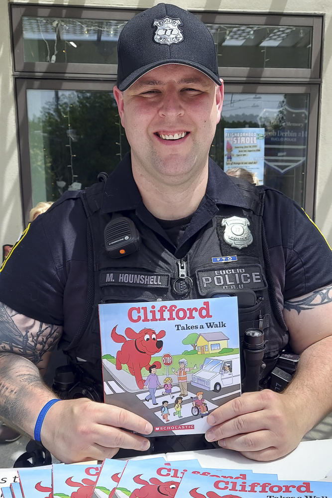 Officer Michael Hounshell of Community Response Unit at the Stroll giving away books to kids