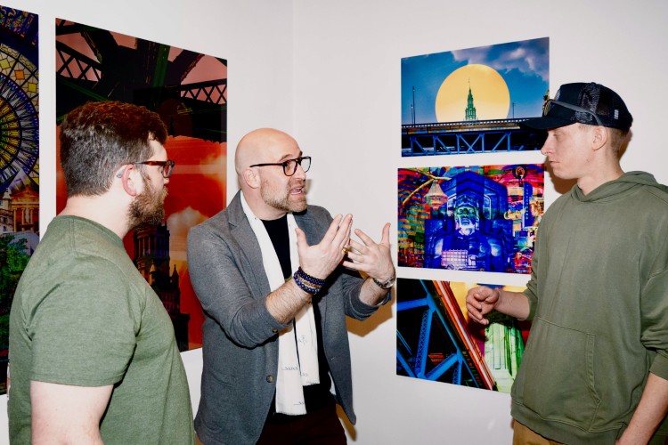 Jason Toth talks to guests in front of "The Beaten Path is Defeated."