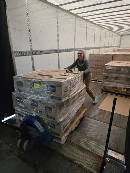 Volunteers pack an entire semi-truck with food donations.