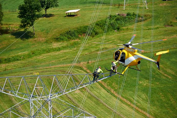 FirstEnergy linemen are dropped onto transmission towers.