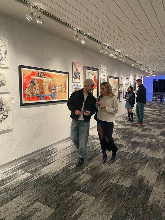 A young couple takes a stroll through the Derek Hess exhibit.