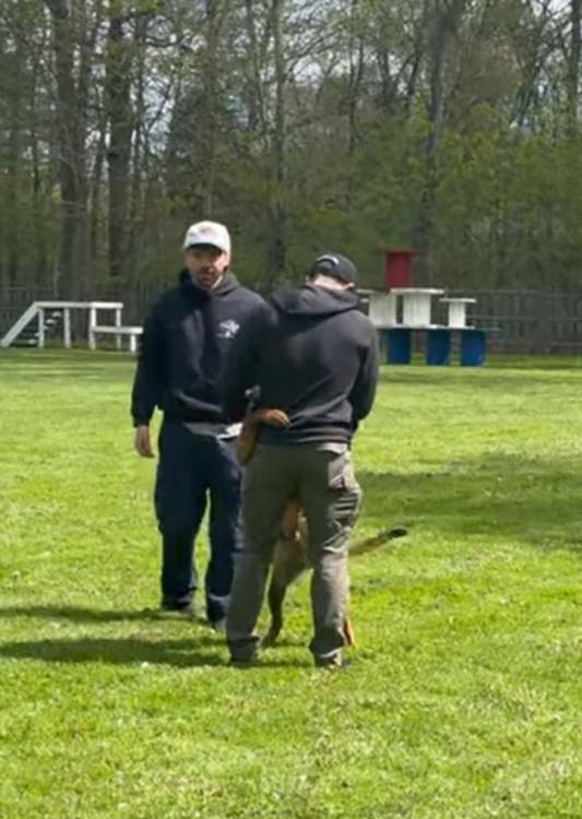 K-9 trainer Ryan Shaughnessy (left) watches as Officer Jeremy Puszakowski and K-9 Chinook meet for the first time.