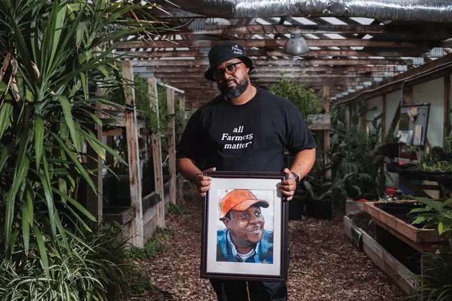 Tim Lewis proudly displays a painting of his late mentor, Rid-All Green Partnership co-founder Damien Forshe.