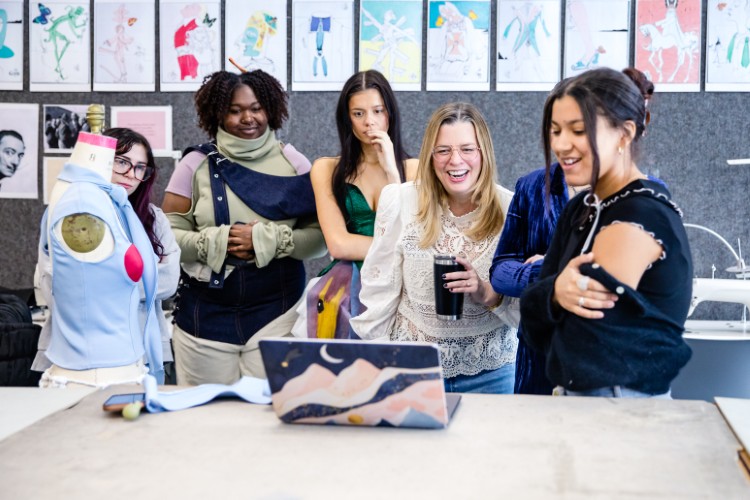 Jacqueline Hughes (center), lecturer in Kent State University’s School of Fashion, evaluates a student’s design for the Salvador Dali project.