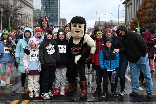 The Cavs' Sir C.C. poses for photos with the runners.