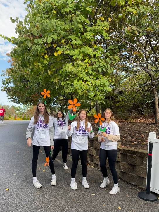 Walkers carry symbolic orange flowers, which represent advocacy and general support for the cause.