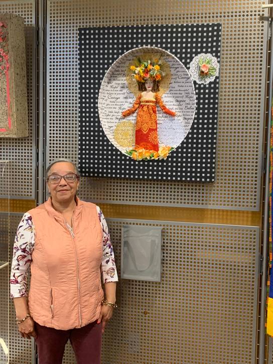 Joyce Morrow Jones standing in front of her work at CCPL's Parma-Powers Branch gallery space inaugural show in spring 2024.