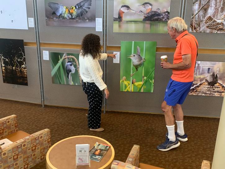 CCPL's Parma-Powers Branch manager Jessica Breslin (left), and patron Walter Bubna admire Walter’s favorite photograph.