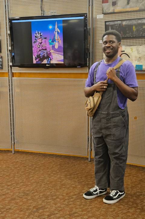 Artist and Cleveland Institute of Art senior Cameron Wright, standing in front of their digital collage, Space Junky.