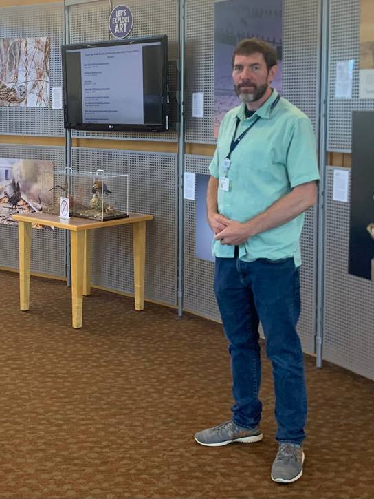 Chad Lowther standing in front of the Cuyahoga County Public Library, Parma-Powers Branch Art Wall.