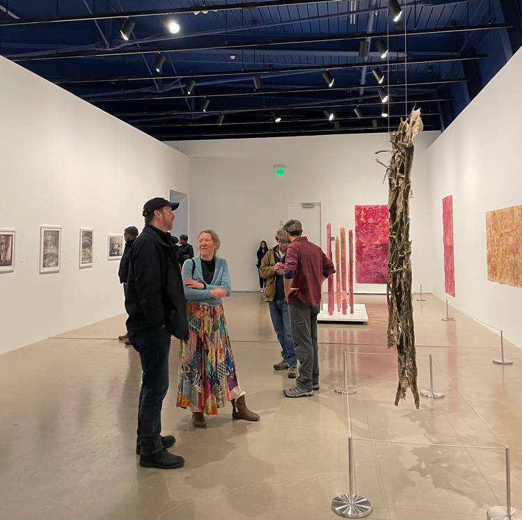 Guests mingle and study the four exhibits at moCa's recent 2026 season opening event.