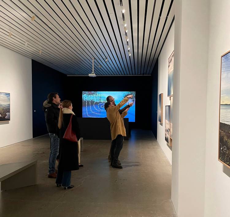 Guests mingle and study the four exhibits at moCa's recent 2026 season opening event.