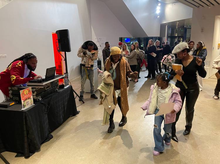 Pausing to enjoy DJ Silk at Visitors study the work of Akron artist Avery Mags Duff at moCa Cleveland's 2026 season opening event..