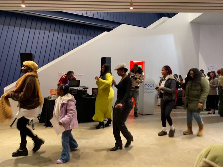 Pausing to enjoy DJ Silk at Visitors study the work of Akron artist Avery Mags Duff at moCa Cleveland's 2026 season opening event..