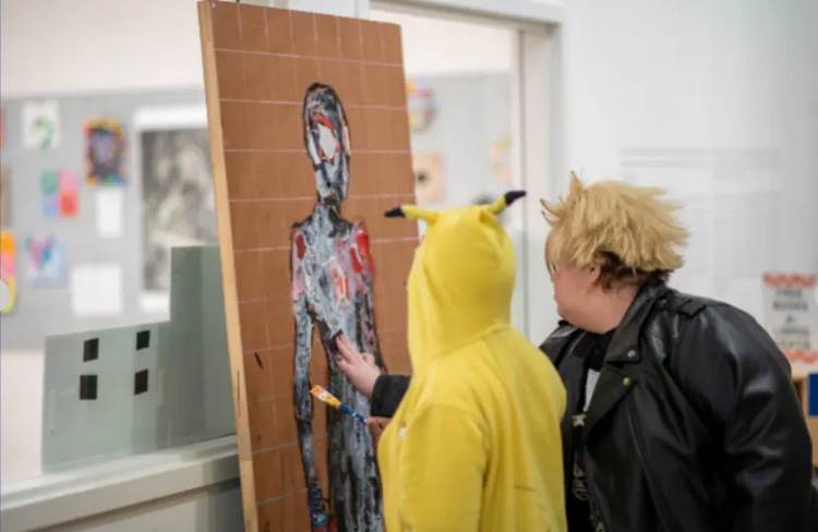 Teens participate in a painting event at a Kids ComicCon activity.