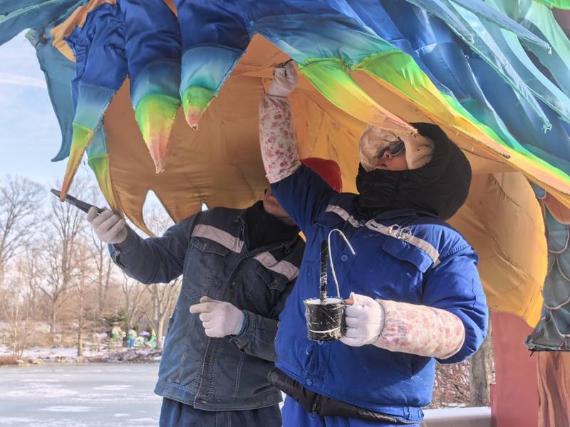Members of the Tianyu team paint a lantern.