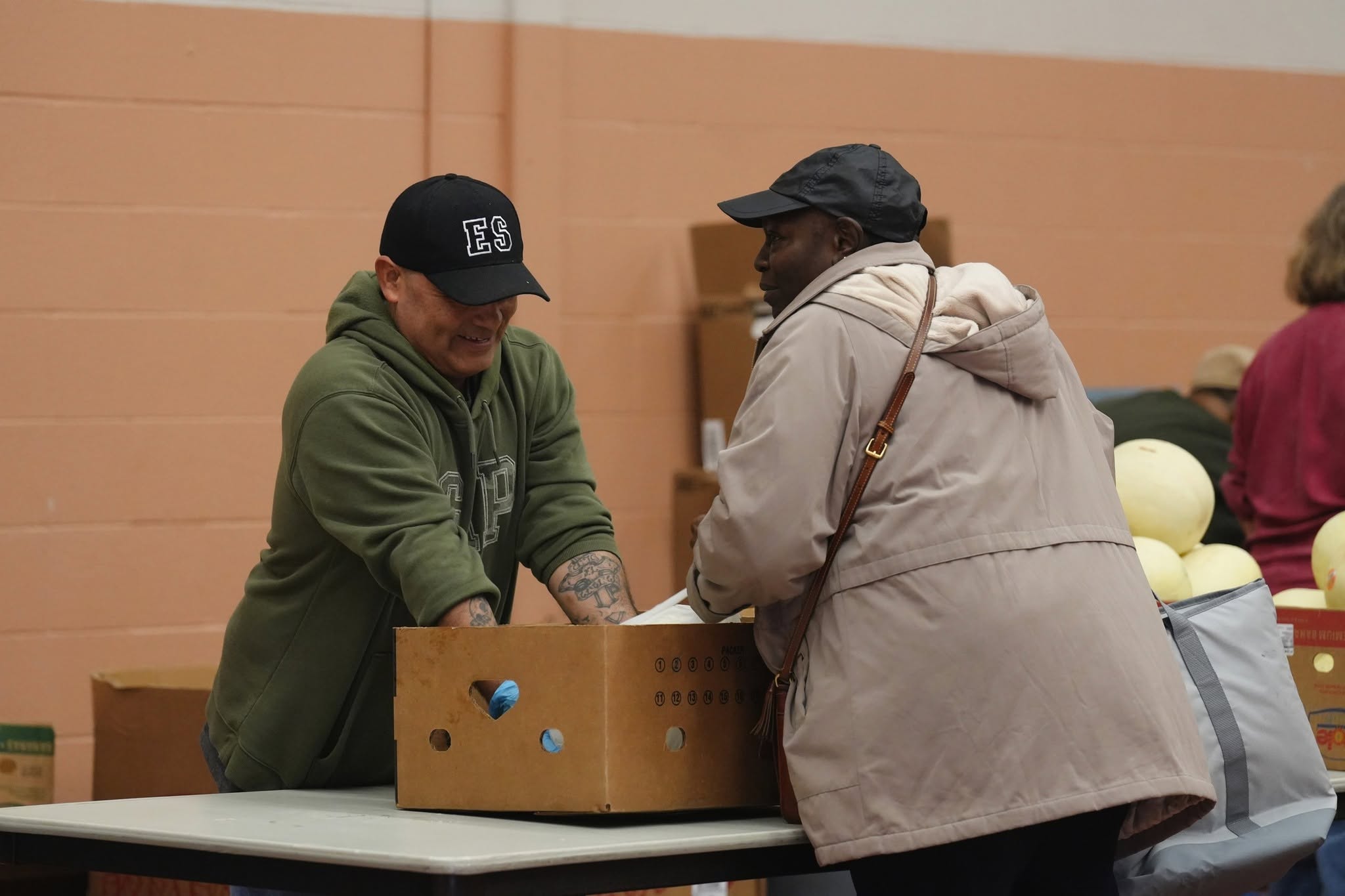 A Salvation Army volunteer packs up a box of produce for a visitor during a recent giveaway.