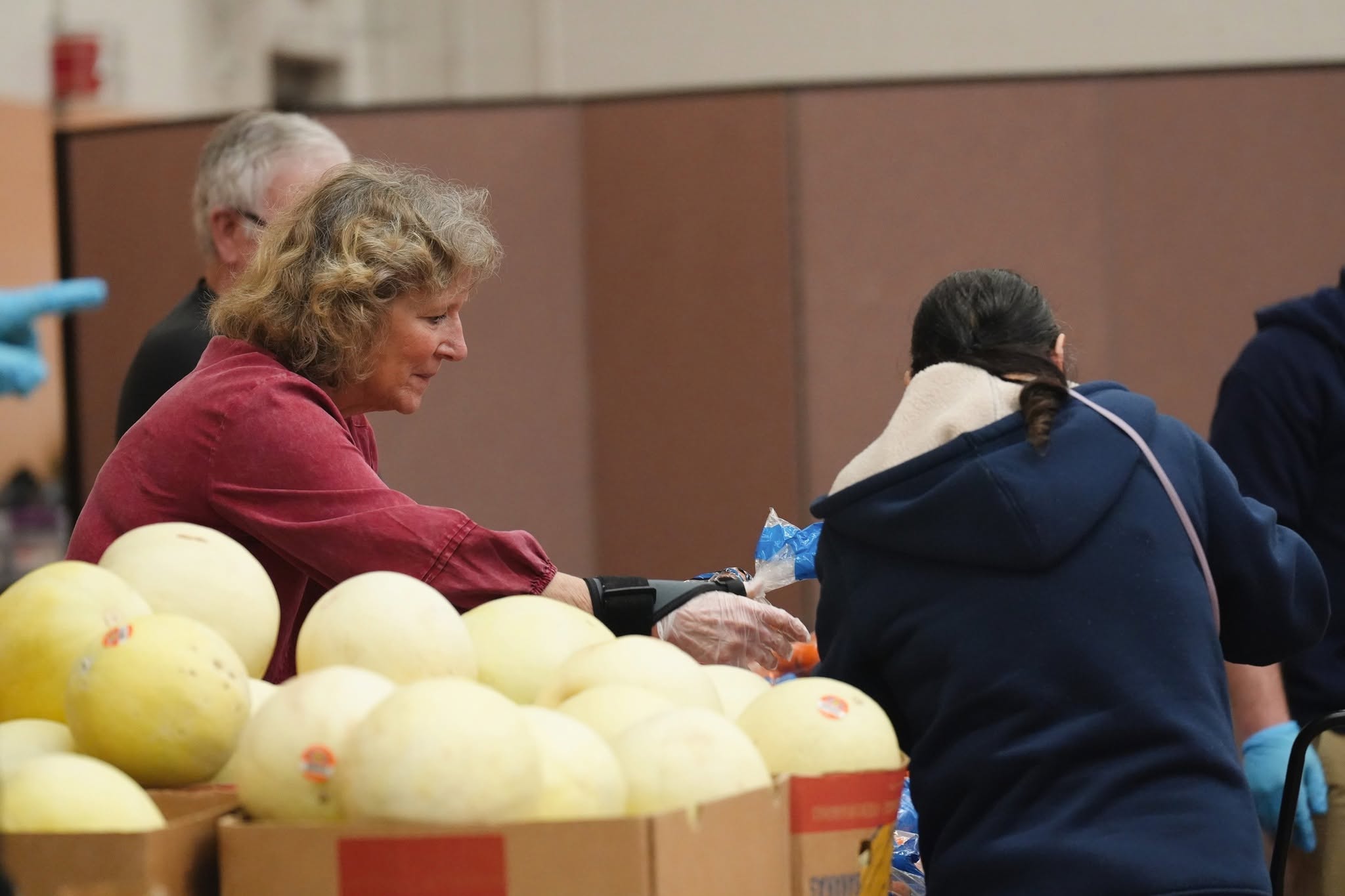 Guests sort through the melons and other produce available at a disctribution.