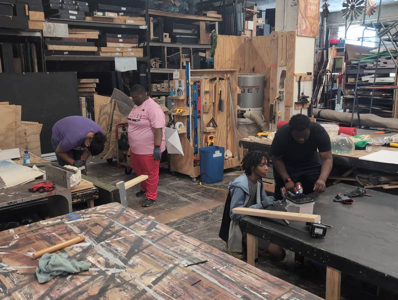 The technical theater crew members build sets.