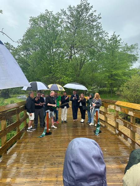 Derek Schafer of West Creek Conservancy helps cut the ribbon marking the opening of the West Creek Greenway.
