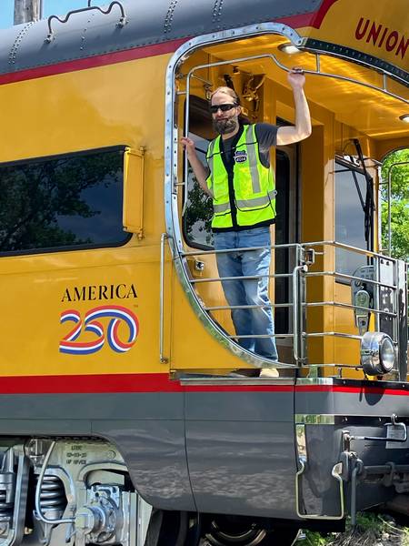 A member of the train crew looks out at all the onlookers at the Euclid stop.