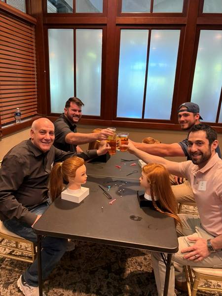 Fathers learning to style their daughters' hair for the Pints and Ponytails event.