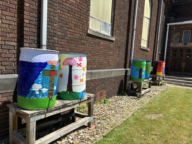 Left, tstudetsdesigned a barrel combining  faith and the environment. Right, two students painted flowers and butterflies.