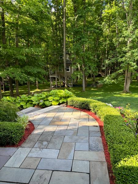 The paver path into a garden of a grand home on the tour.