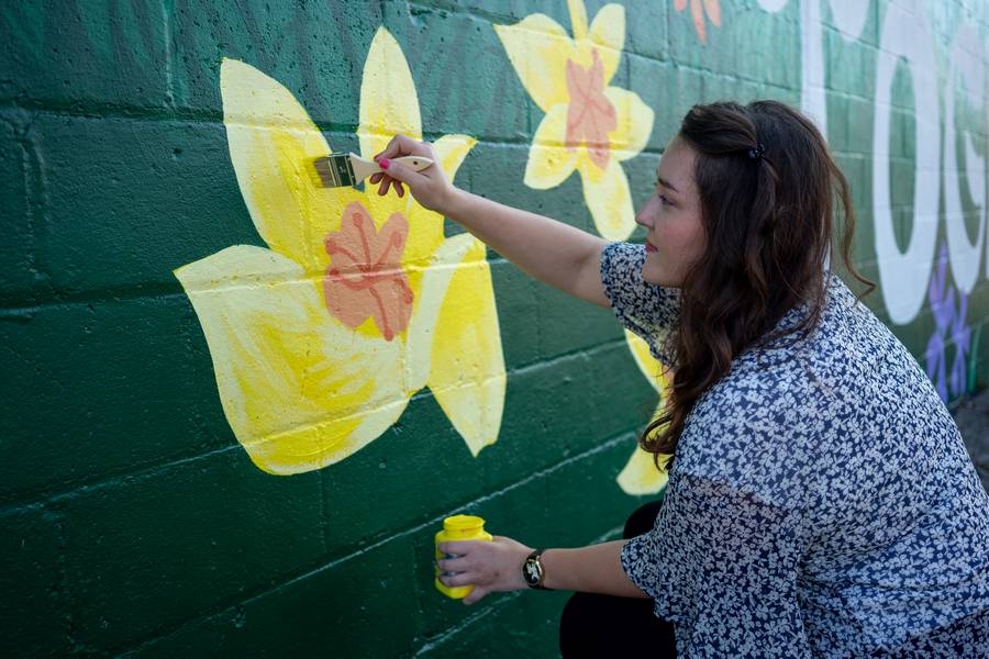 Artist Olivia Oltmanns paints a daffodil in 'Grow Together.'