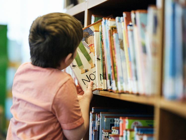 A boy selects a book to look over at the Cuyahoga County Public Library.