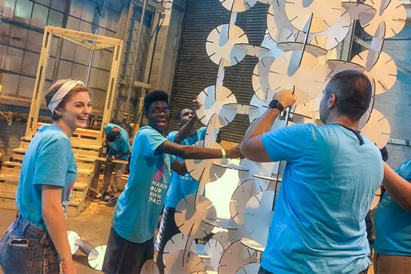 (MOOS) kids at IngenuityFest making towering art sculptures out of interlocking would-be flower discs