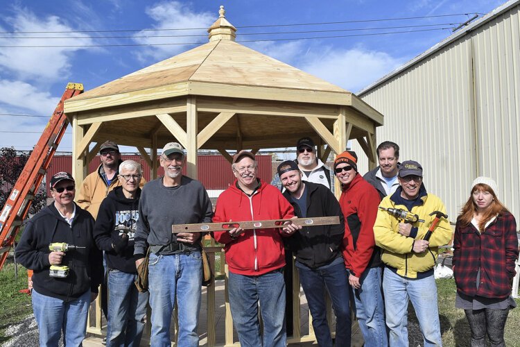 Michael Sering with staff and volunteers finishing gazebo construction at the greenspace for the guys, next to the shelter, on a Landbank donated plot.