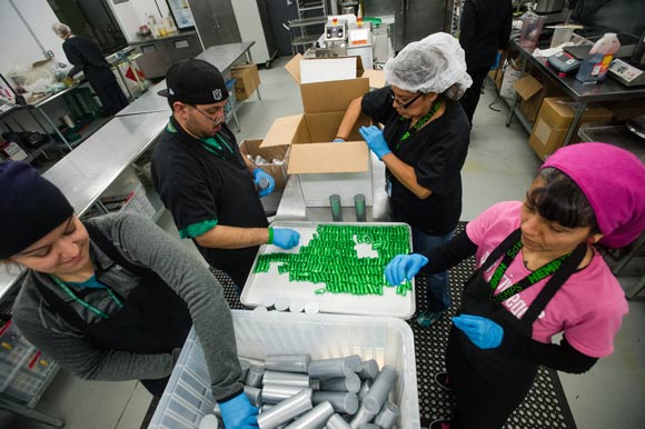 The Mile High City's booming marijuana industry has created and catalyzed thousands of jobs. Employees at Dixie Elixirs package edible chocolates.