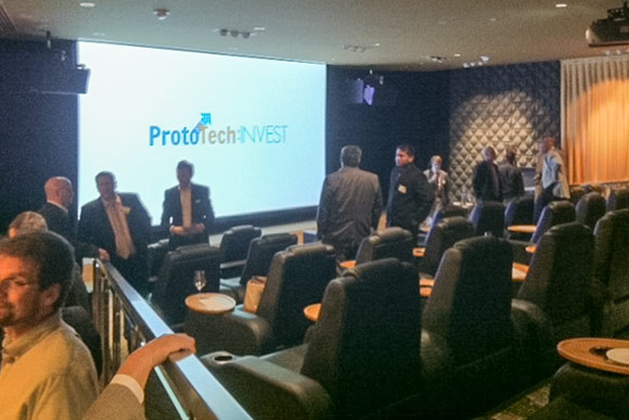 Event attendees mingle around the Alex Theater in the Metropolitan at the 9 to discuss the various product pitches given that afternoon.