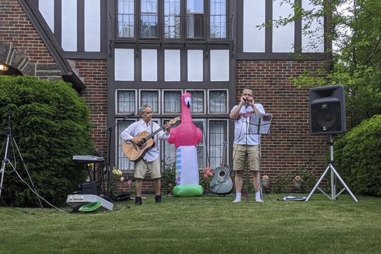 John Thayer plays with childhood friend Mitchell Cronig in an outdoor concert.