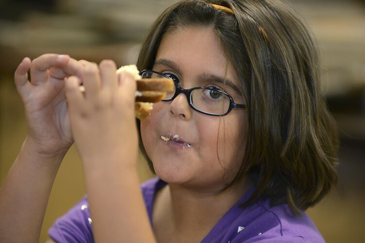 A child enjoys her sandwich at the summer lunch and enrichment program for kids initiated by the Lakewood Community Services Center for kindergarten through fifth graders.