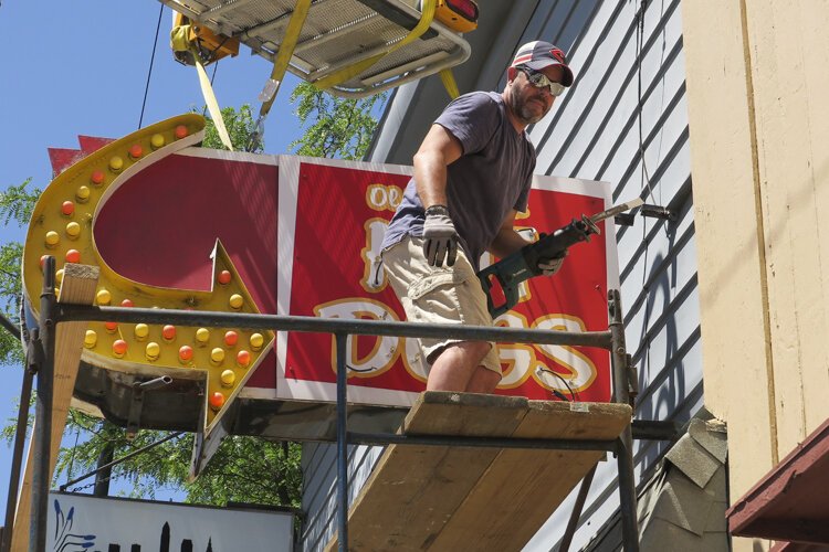 Old Fashion Hot Dogs street sign in the process of removal.