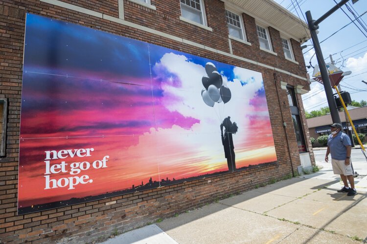 Never Give Up Hope mural by Donald and Ali Black on the side of Henry's Cleaners  at Kinsman Rd. and 116th St.